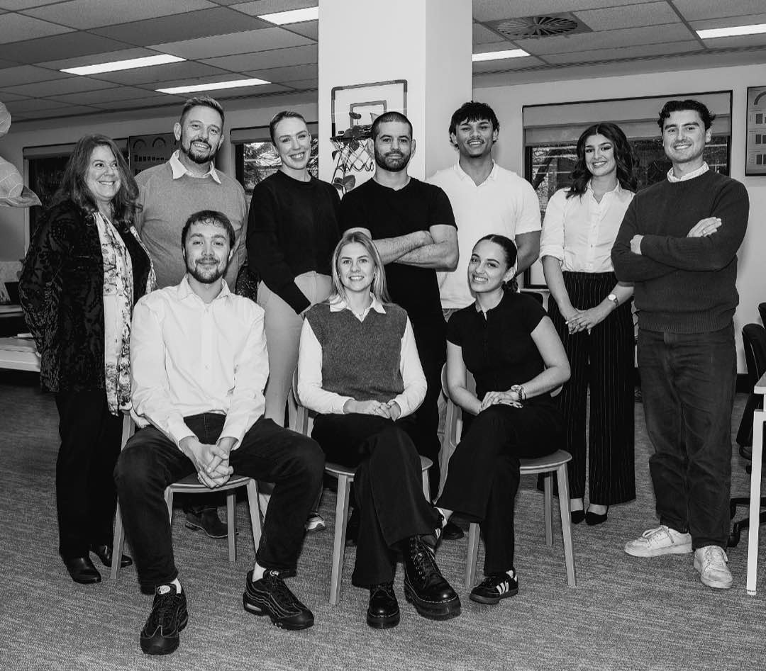 The Hader Institute team, around ten people, gathered together in their office.